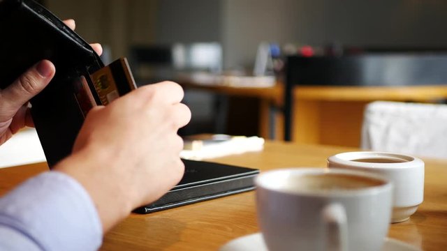 Male hand take creadit card and pay bill in cafe