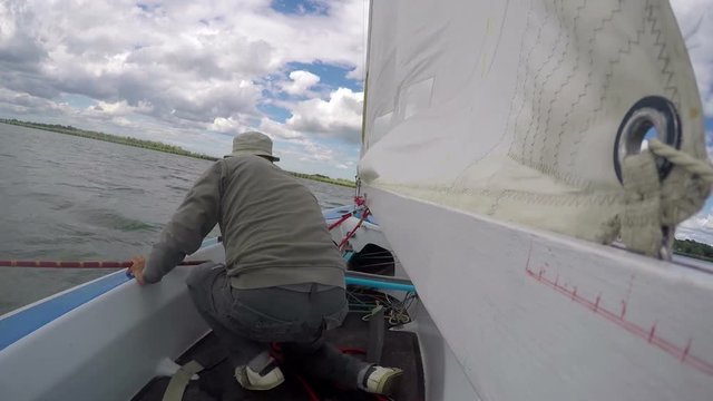 man drives sports yacht, sail boat turn to starboard tack