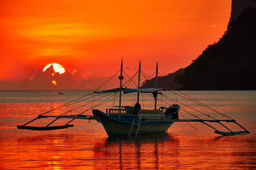 Traditional filippino boat at El Nido bay in sunset lights. 