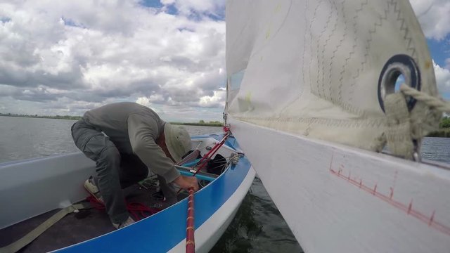 man drives sports yacht, sail boat turn to starboard tack
