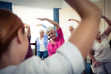 Obraz na płótnie Canvas Group of seniors doing exercises with nurse