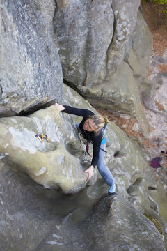 The girl climbs on the rock.