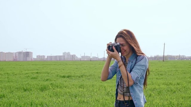 Beautiful young woman taking photos with old film camera. Slow motion