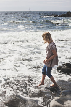 Full length side view of girl entering in sea at beach
