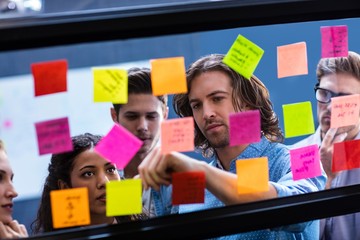 Hipsters reading a post it on a window