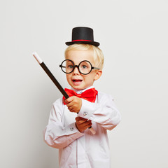 Kind zaubert mit Zauberstab als Zauberer