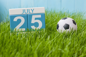 July 25th. Image of july 25 wooden color calendar on greengrass lawn background. Summer day, empty space for text