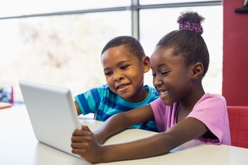 School african american kids using a digital tablet in classroom - Powered by Adobe