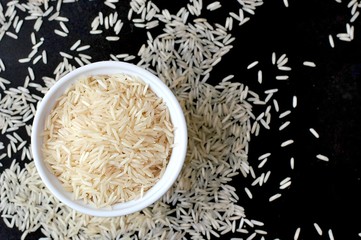 Basmati rice in the bowl on the black background