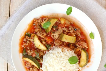 Spicy mincemeat with tomatoes, basil and zucchini with basmati rice