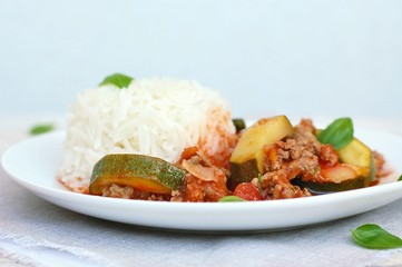 Spicy mincemeat with tomatoes, basil and zucchini with basmati rice
