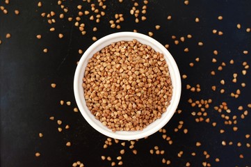 Buckwheat in the bowl on the black background