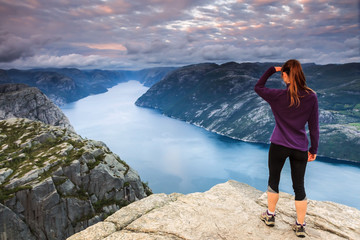 Jeune femme au sommet d'une falaise: randonnée de Preikestolen - Lysefjord - Norvège 