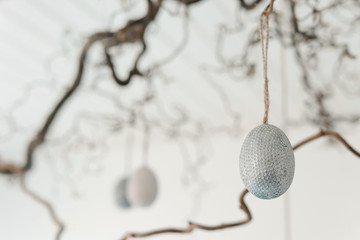 Decorative easter eggs hanging from a twig