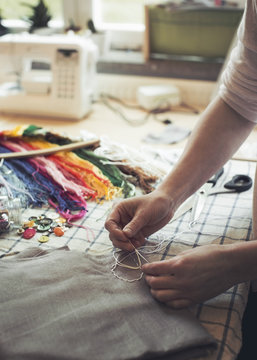 Person sewing with white thread