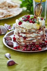 a heap of pancakes smeared with curd and jam
