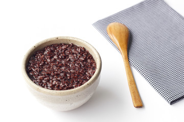 gruel (dark violet rice) in ceramic bow and wooden spoon isolated on white background