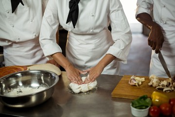 Mid section of head chef making pizza dough