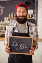 Waiter holding a board written open 