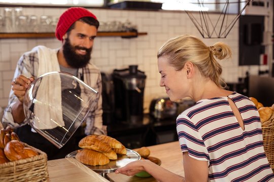 Seller presenting croissants to a customer