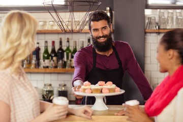 Bartender with customers holding a cup of coffee