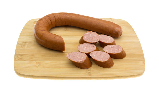 Reduced Calorie Kielbasa Sausage On A Wood Cutting Board Isolated On A White Background Side View.