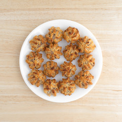 Chocolate chip macaroons on a white dish atop a wood table