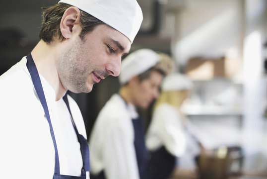 Side view of baker in kitchen at bakery