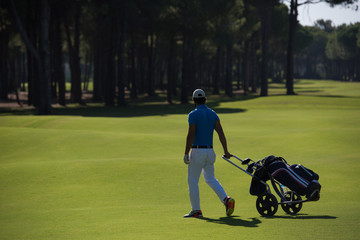 golf player walking with wheel bag