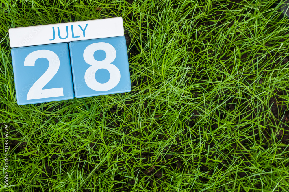 Wall mural July 28th. Image of july 28 wooden color calendar on greengrass lawn background. Summer day, empty space for text