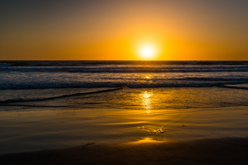 Fototapeta na wymiar Beach of Pacific Ocean. Magnificent panorama of sunset over the ocean.