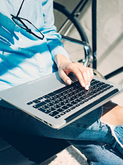 Work process modern Studio Loft.Creative Art director working coworkers office with new freelance business startup.Using Laptop on knees,holding glasses hand.Horizontal.Film effect.Blurred background.