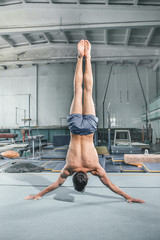 caucasian man gymnastic acrobatics equilibrium posture at gym background