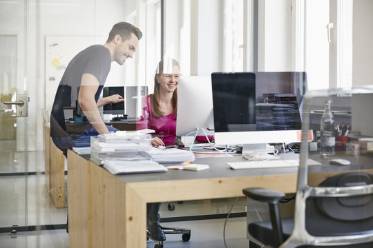 Man and woman working in office, smiling