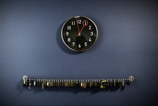 Padlocks hanging on railing with clock at gym's locker room
