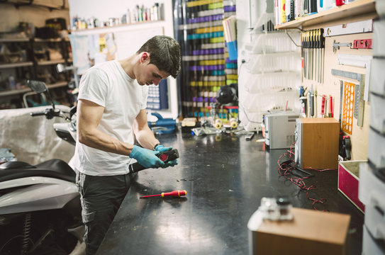 Electronic technician fixing an electronic device at workbench