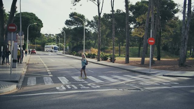 Tourist girl pedestrian cross the road by zebra crossing