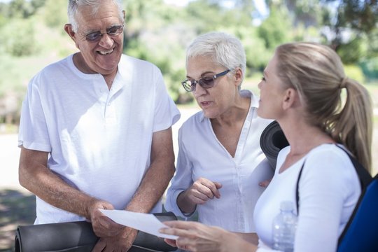 Elderly couple with fitness instructor outdoors