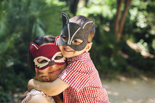 Mother and little son with animal masks playing in the park