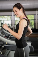 Obraz na płótnie Canvas Happy woman jogging on treadmill