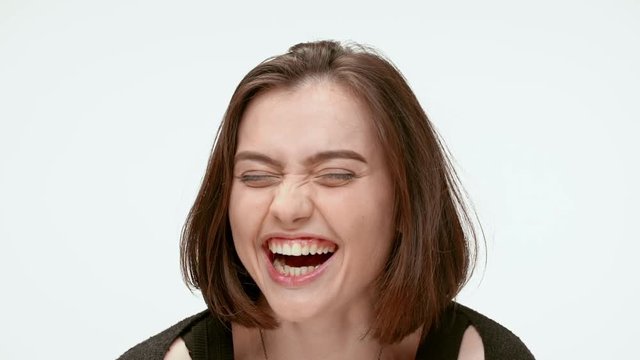 Cute brunette girl laughing out loud. Close up. Slow motion