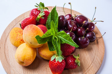 fruits and berries on a wooden cutting board