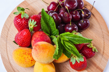 fruits and berries on a wooden cutting board