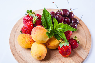 fruits and berries on a wooden cutting board