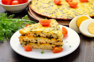 Homemade omelet with herbs and vegetables on wooden background,