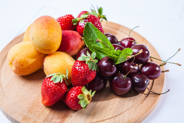 fruits and berries on a wooden cutting board