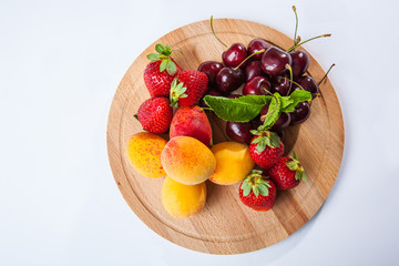 fruits and berries on a wooden cutting board