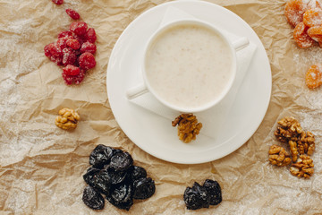Oat meal with walnuts and berries. Parchment background. Flat Lay.