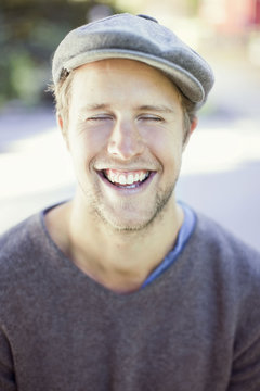 Happy man wearing flat cap outdoors