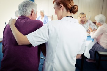 Nurse assisting a senior using a walker 